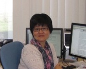 Xing Dai sitting at her desk while looking at the camera